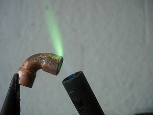 Find a piece of oxidized copper and hold it with pliars in front of your torch.
